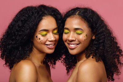 Shirtless women with face paint against wall