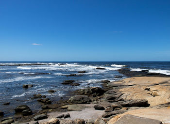 Scenic view of sea against clear blue sky