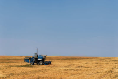 Tractor on field against clear sky