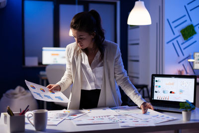 Woman making progress report while working at office