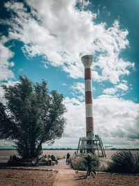 Low angle view of smoke stack on field against sky