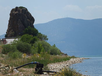 Scenic view of mountain by sea against sky