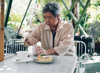 Young woman with coffee cup on table at restaurant