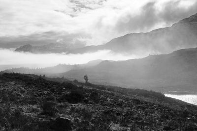 Scenic view of mountains against cloudy sky