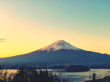 Scenic view of snowcapped fuji mountain against sky during dawn