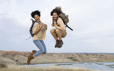 Carefree couple with backpacks jumping together