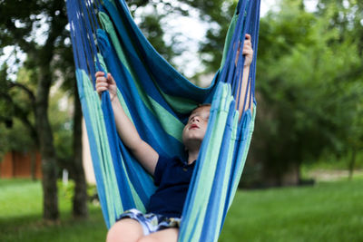 Boy playing in hammock at park