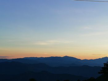 Scenic view of silhouette mountains against sky during sunset