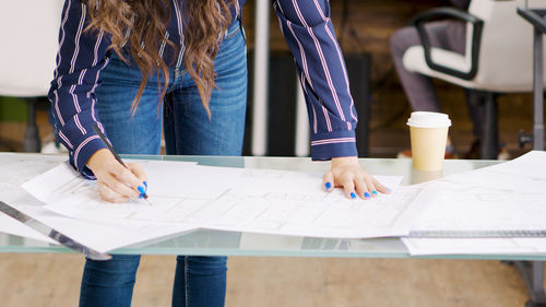 Midsection of woman using laptop on table