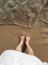 Low section of woman standing on beach