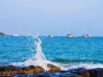 Sailboats in sea against clear sky