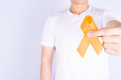 Close-up of woman holding hands over white background