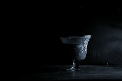 Close-up of empty glass on table against black background