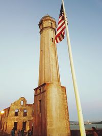 Low angle view of flags against clear sky