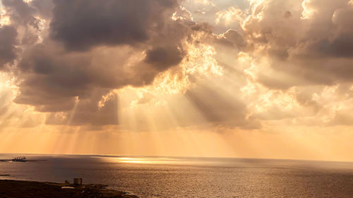 Beautiful sunset with light going through clouds over the sea
