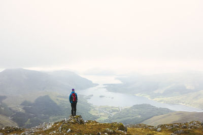 High angle view of man standing on mountain against sky