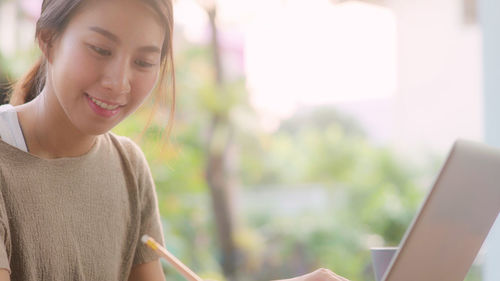 Portrait of young woman using mobile phone