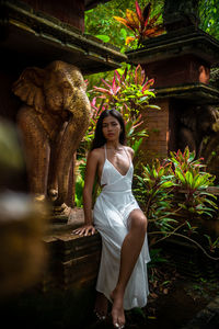 Portrait of young woman standing against temple