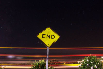 Light trails on road against sky at night