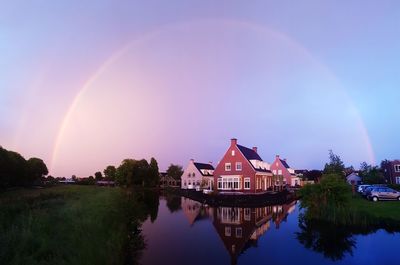 Scenic view of rainbow over river against sky