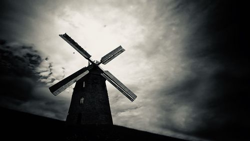 Low angle view of traditional windmill against sky