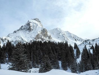 Low angle view of snowcapped mountains against sky