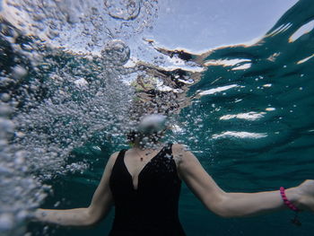 Rear view of woman swimming in sea