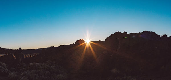 Scenic view of mountains against clear sky during sunset