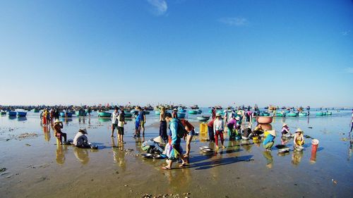 Panoramic view of people on beach against clear sky