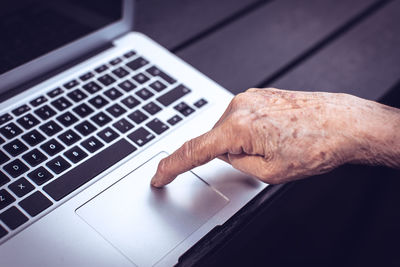 Old persons finger on computer keyboard