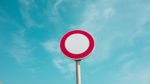 Low angle view of road sign against blue sky