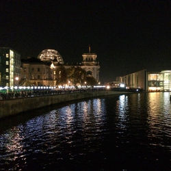 Illuminated buildings with waterfront at night