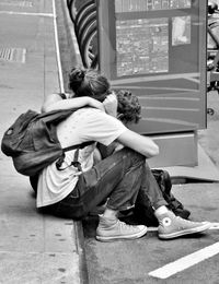 Rear view of couple sitting in city