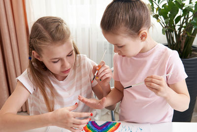 Sisters painting at home