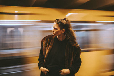 Rear view of woman standing on train at subway station