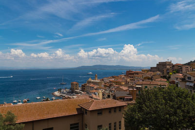 High angle view of townscape by sea against sky