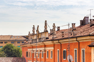 Statue on roof of building against sky