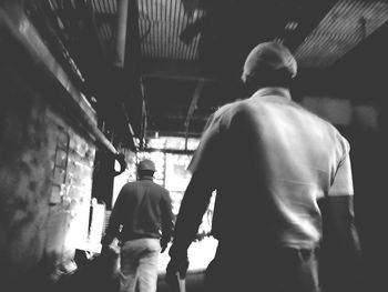 Rear view of men walking in corridor