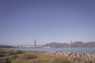 View of suspension bridge against clear blue sky