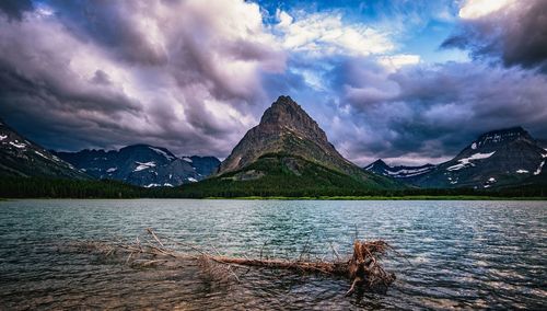 Scenic view of lake by mountain against sky