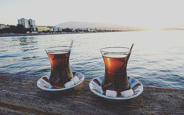 drink, water, refreshment, food and drink, table, sea, sky, drinking glass, outdoors, nautical vessel, freshness, no people, built structure, close-up, sunlight, day, building exterior, focus on foreground, sunset, river