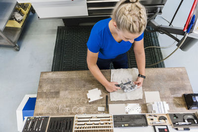 Woman measuring metal workpiece