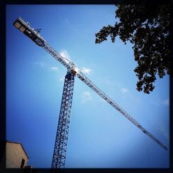 Low angle view of crane against sky