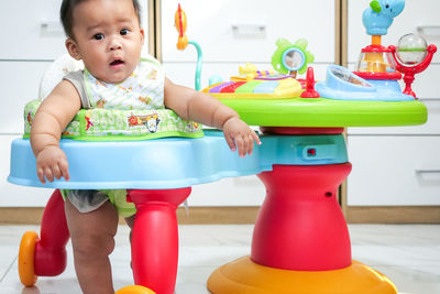 Cute boy playing with toy on table