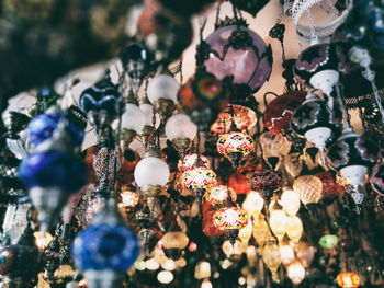 Low angle view of illuminated lighting equipment for sale hanging in store