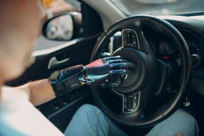 Cropped hand of man driving car