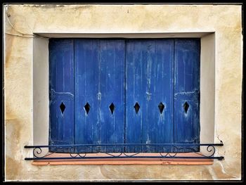 Close-up of closed window of old building