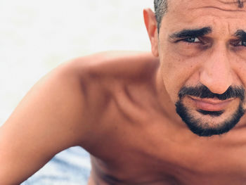 Close-up portrait of shirtless bearded man