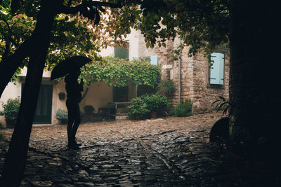 Man standing on footpath by building