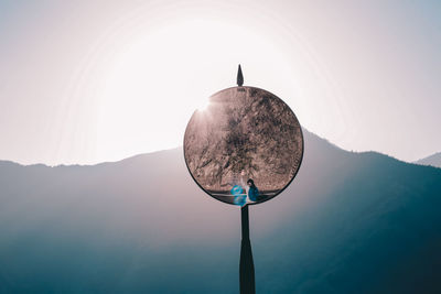 Low angle view of parking mirror against sky